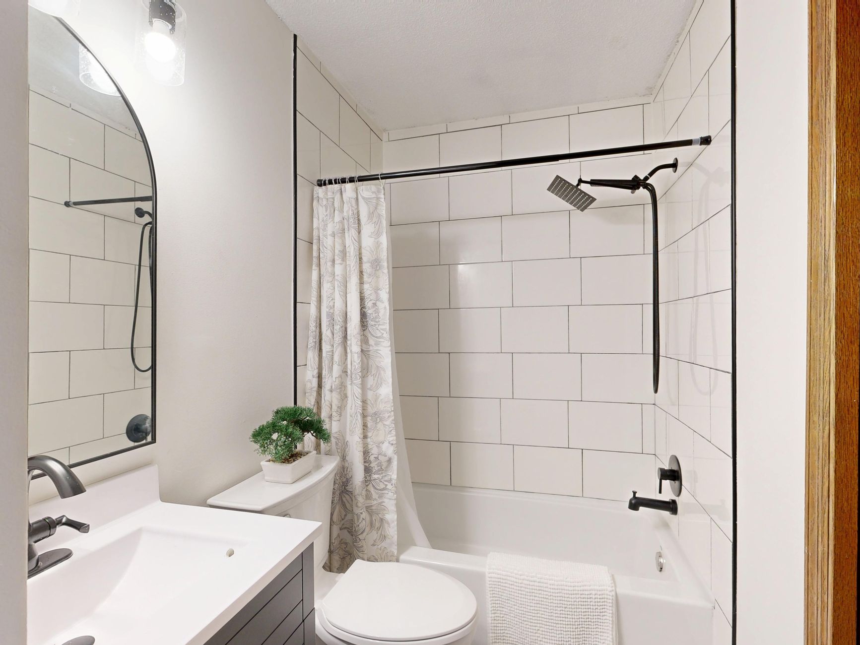 Sleek and clean modern bathroom with white tiles and black fixtures in Riverside, CA